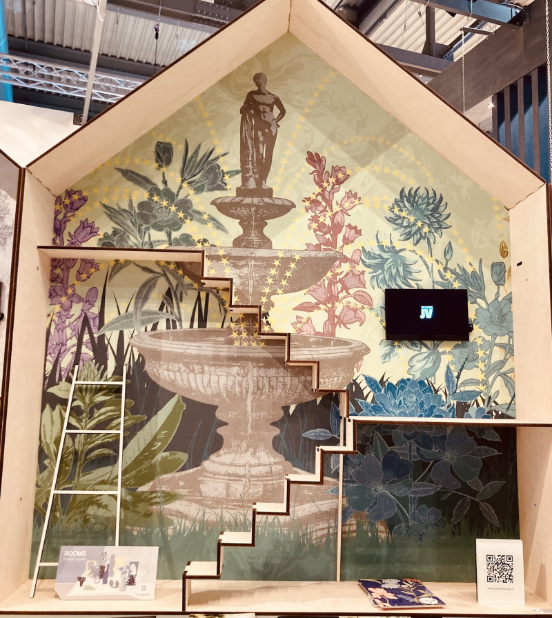 Tapentenpräsentation, kleines Modellhaus im Querschnitt mit angedeuteten Stockwerken, Treppen und Leiter, Tapetenmotiv: Garten mit Brunnen