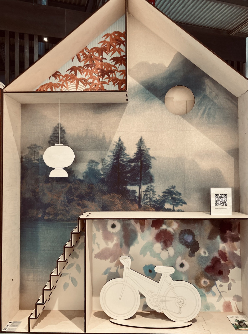 Tapentenpräsentation, kleines Modellhaus im Querschnitt mit angedeuteten Stockwerken, Treppe, 2 Lampen, 1Motorrad, Tapetenmotive: Herbstblätter, Landschaft, Blumen